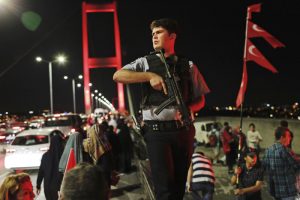 A Turkish police officer patrols as pro-government supporters, gather on Istanbul's iconic Bosporus Bridge, Thursday, July 21, 2016.