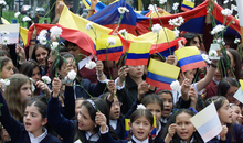 Students celebrating International Women's Day hold Colombian flags and flowers during march to demand the release of dozens of kidnapped children, Bogota.