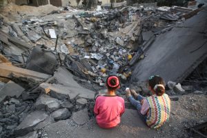 Menores palestinas frente a un edificio destruido en Gaza // Photo by Majdi Fathi/NurPhoto via Getty Images